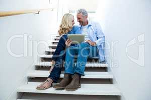 Full length of smiling couple using digital tablet
