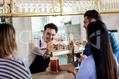 Friends talking to barkeeper while having drinks