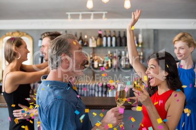 Group of friends holding glass of champagne flute while dancing