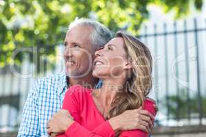 Mature couple standing against fence