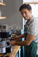Waiter making cup of coffee at cafe