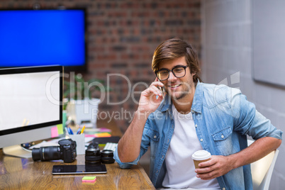 Young man talking on mobile phone in office