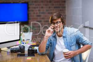 Young man talking on mobile phone in office
