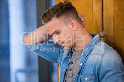 Depressed man standing by door