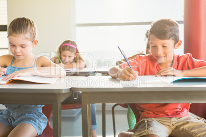 Schoolkids doning homework in classroom