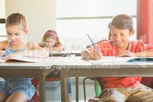 Schoolkids doning homework in classroom