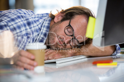 Businessman napping on computer desk