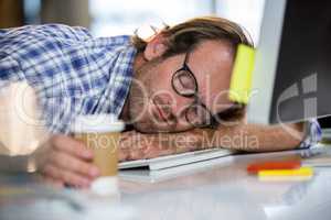 Businessman napping on computer desk