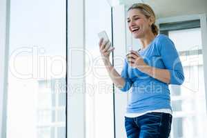 Low angle view of smiling woman using phone