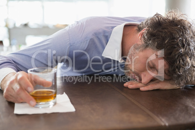 Drunken man sleeping on a bar counter