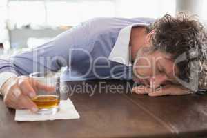 Drunken man sleeping on a bar counter