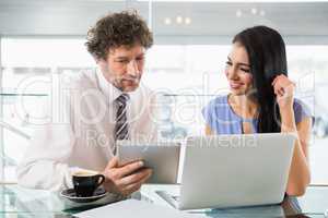 Businessman discussing with colleague over digital tablet