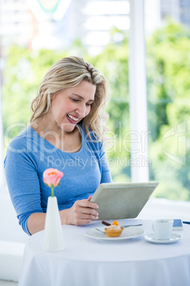Smiling mature woman holding digital tablet