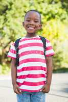 Happy schoolboy standing in campus