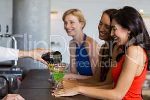 Waiter pouring cocktail into cocktail glass