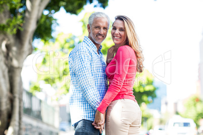 Romantic mature couple standing by tree