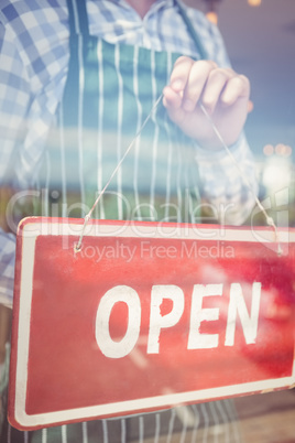 Waiter holding open signboard