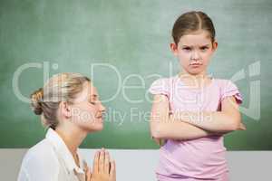 Female teacher apologizing girl in the classroom