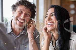 Couple listening to music together in cafeteria