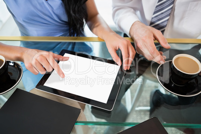 Businessman discussing with colleague over digital tablet