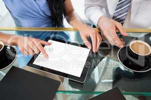 Businessman discussing with colleague over digital tablet