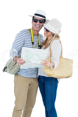 Mid adult couple holding map against white background