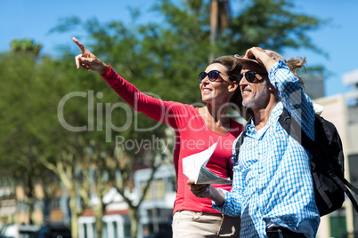 Mature couple standing at street on sunny day