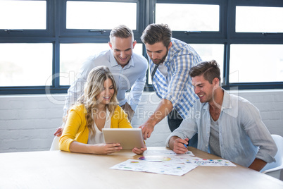 Business people discussing over tablet computer