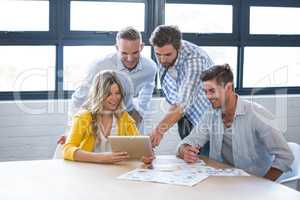 Business people discussing over tablet computer