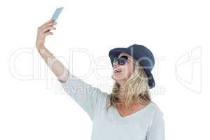 Woman taking selfie against white background