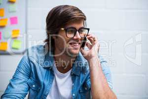 Happy man talking on phone in office