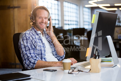 Smiling creative businessman working at desk