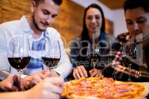 Friends enjoying pizza and wine