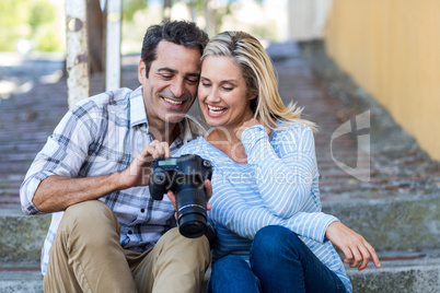 Couple looking in camera while sitting on steps