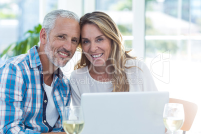 Mature couple sitting by table in restaurant