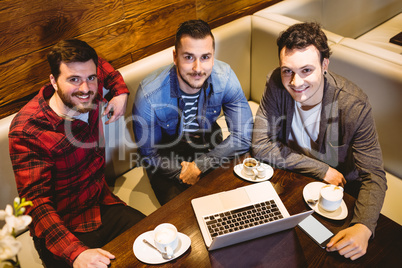 High angle portrait of male friends with laptop