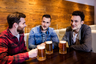 Young friends enjoying beer at restaurant