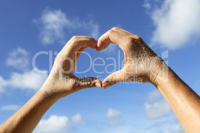 Hands with sand show love symbol