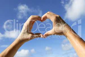 Hands with sand show love symbol
