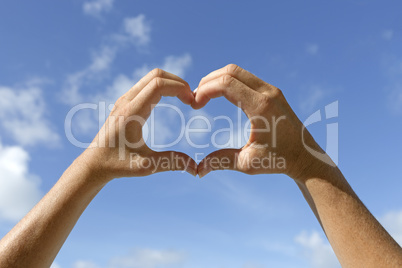 Female hands shows love sign in the air