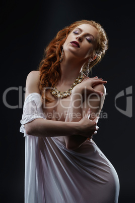 Sensuality and luxury. Red-haired model posing