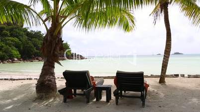 Sunny and tropical beach view with deckchairs, Seychelles