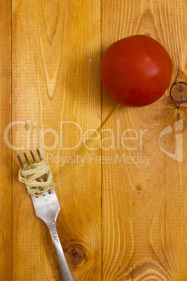 Pasta wrapped around fork and tomato