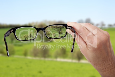 Hand holding glasses to see clearly