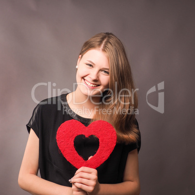 Happy young woman with a red heart shape