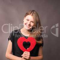 Happy young woman with a red heart shape