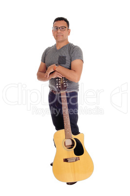Hispanic man standing with guitar.