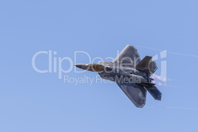 F-22 Raptor in flight with vapor clouds