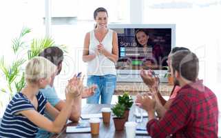 Composite image of colleagues clapping hands in a meeting