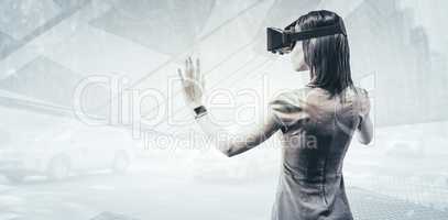 Composite image of rear view of businesswoman holding virtual gl